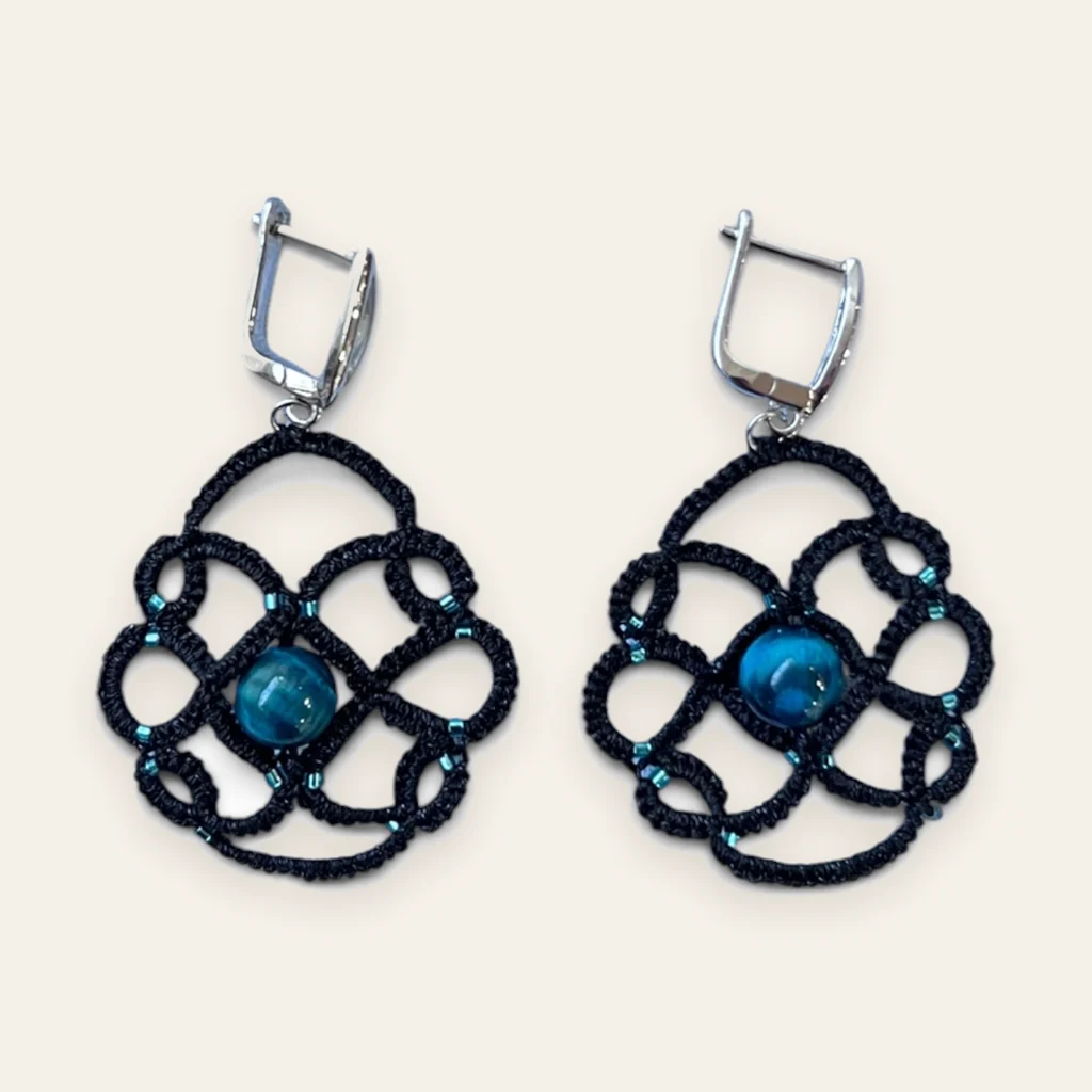 Aros Gota del Atlántico: aros medianos de encaje frivolité tejido a mano en hilo negro, con cuenta azul veteada de aspecto mineral y mostacillas turquesa