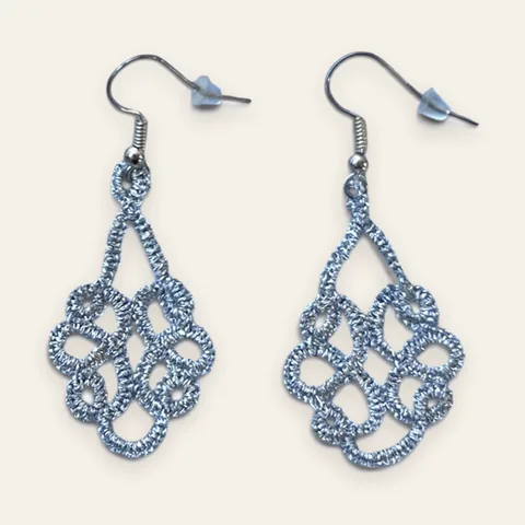 Aros Lluvia de Plata: aros largos de encaje frivolité tejido a mano en hilo metalizado plateado con reflejo celeste, con sin cuentas: encaje puro