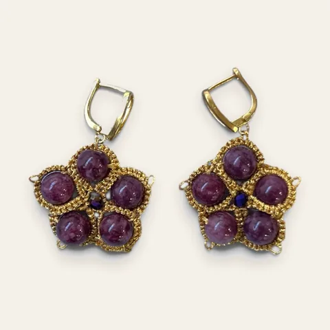 Aros Pétalos de Vino: aros medianos de encaje frivolité tejido a mano en hilo metalizado dorado, con cuentas redondas color vino de aspecto mineral y un cristal facetado azul oscuro