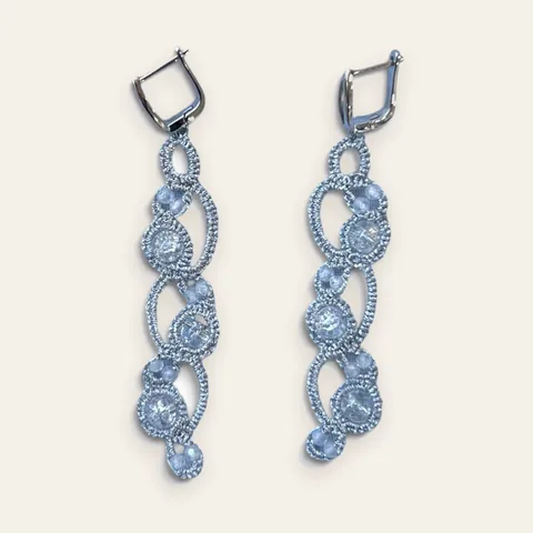 Aros Río de Cristal: aros largos de encaje frivolité tejido a mano en hilo metalizado plateado, con cristales facetados transparentes, grandes y chicos