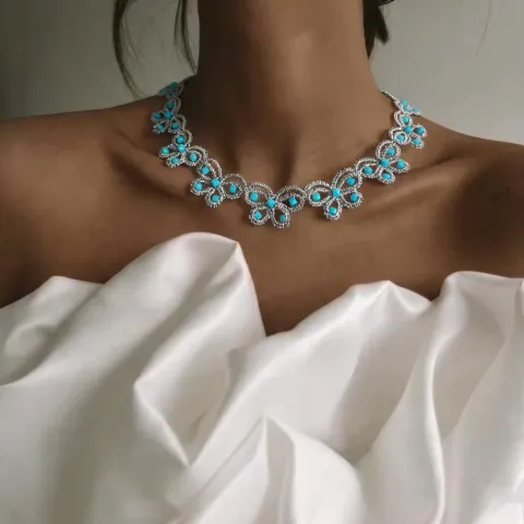Collar Brisa Azul de encaje frivolité gris plata con ágatas celestes, puesto en el cuello