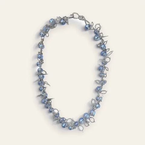 Collar Brisa Helada: gargantilla de encaje frivolité tejido a mano en hilo metalizado plateado, con cristales facetados color celeste