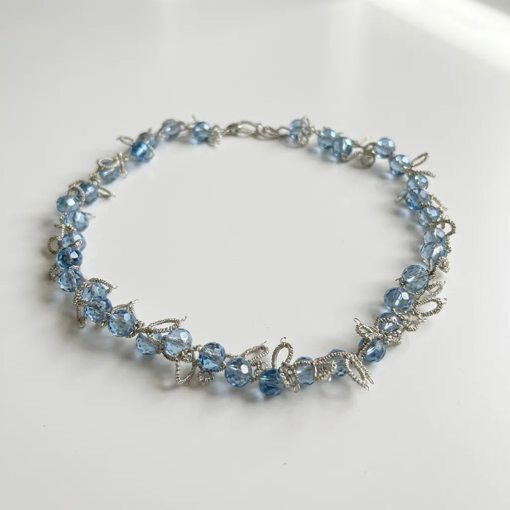 Collar Cristal Azul de encaje frivolité con cuentas facetadas celestes e hilo plateado, sobre fondo blanco