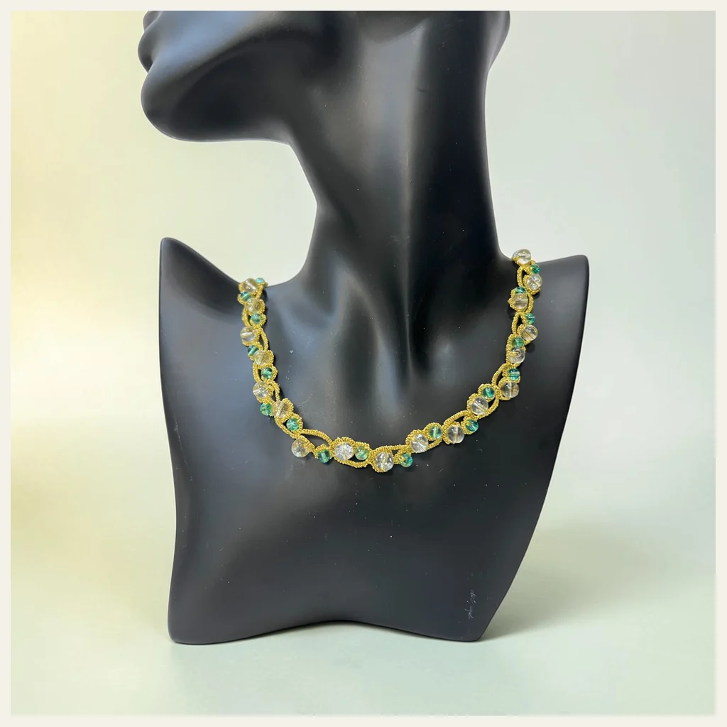 Collar Laguna Dorada: gargantilla de encaje frivolité tejido a mano en hilo metalizado dorado, con cuentas de vidrio transparente y cuentas verdes