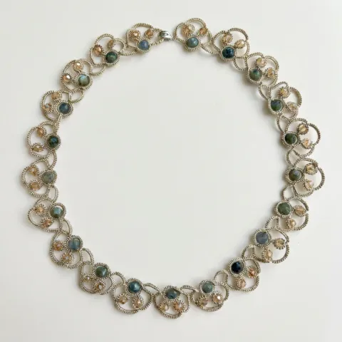 Collar Rocío Marino de encaje frivolité plateado con cuentas de ágata verdes, sobre fondo blanco