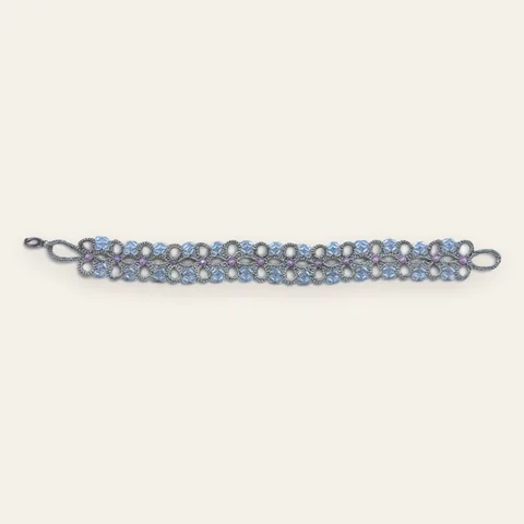 Pulsera Cerezos en Flor: pulsera ancha de encaje frivolité tejido a mano en hilo metalizado gris plata, con cristales facetados celeste, blanco hielo y rosa lila