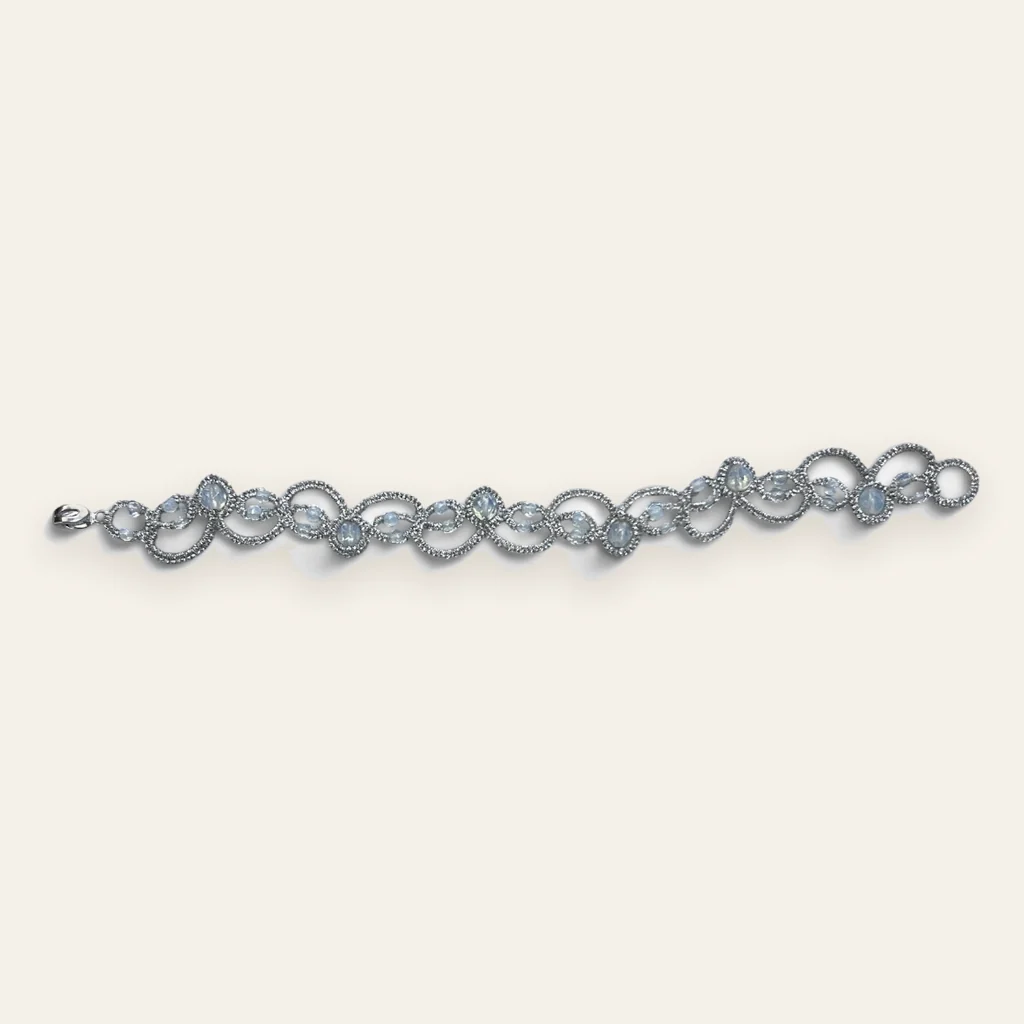 Pulsera Luz de Luna: pulsera de eslabones de encaje frivolité tejido a mano en hilo metalizado plateado claro, con cuentas opalescentes blanco azuladas