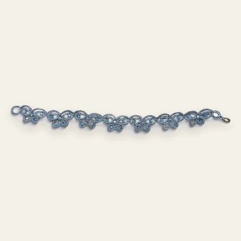 Pulsera Mariposa de Hielo: pulsera de eslabones de encaje frivolité tejido a mano en hilo metalizado plateado, con cristales facetados color celeste hielo