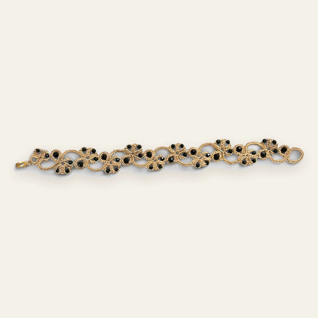 Pulsera Ónix Dorado: pulsera de eslabones de encaje frivolité tejido a mano en hilo metalizado dorado, con cristal facetado negro