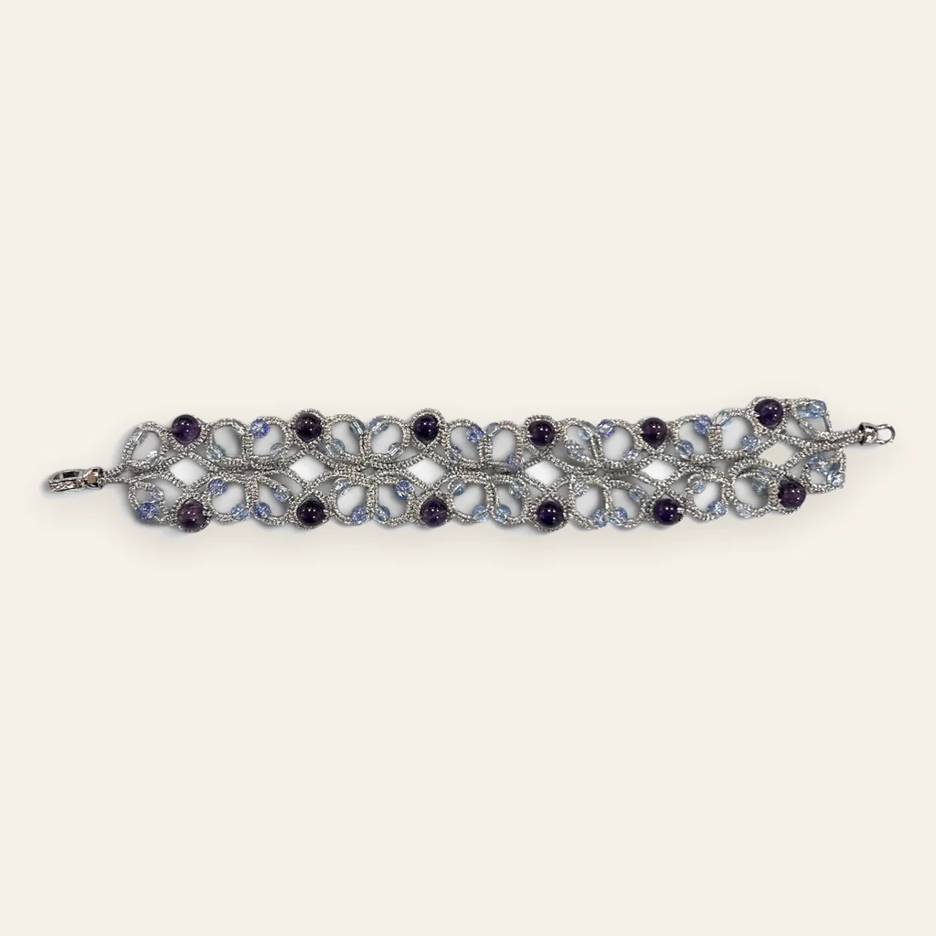 Pulsera Violeta de Plata: pulsera ancha de encaje frivolité tejido a mano en hilo metalizado plateado mate, con cuentas redondas violeta oscuro y cuentas translúcidas celeste lila